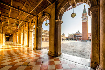 Arches of Correr museum with San Marco tower on the main square in the morning in Venice