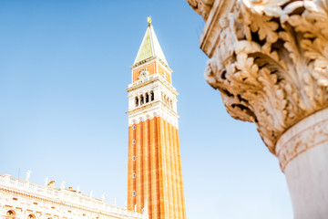 Fototapeta na wymiar Saint Mark's Campanile on the main square in Venice. Close-up view with column fragment