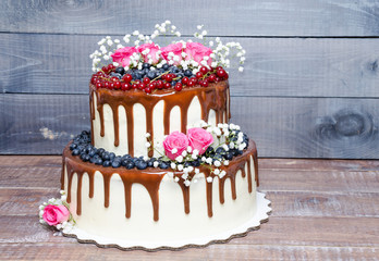 two layered color drip wedding cake with bilberries, red currant