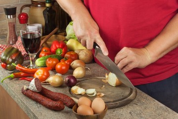 Chef sliced onion on board. Preparing vegetables for healthy salad. Slicing onions and tomatoes. Fresh vegetables in the kitchen.
