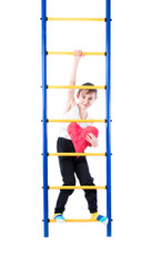 Little boy standing on a colorful stairs and holding a red heart on a white background