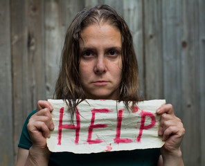 A girl holding a sheet of paper on which is written 