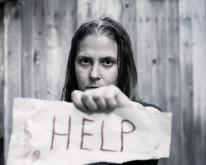 A girl holding a sheet of paper on which is written 