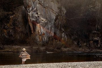 beautiful woman traveler  wearing hat and poncho, looking at ama