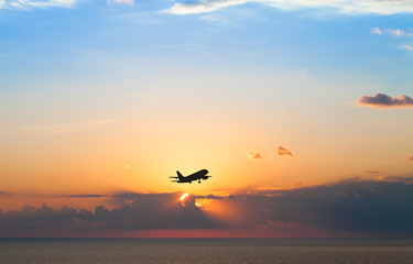 Black silhouette of an airplane on a background of a beautiful s