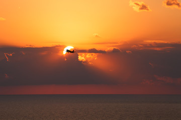 Black silhouette of an airplane on a background of a beautiful s