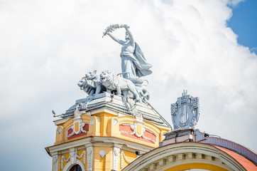 Statue on allegorical car pulled by lions on a tower at the Cuj-Napoca National Theatre and Opera House in the Transylvania region of Romania. A baroque rococo building in a close view
