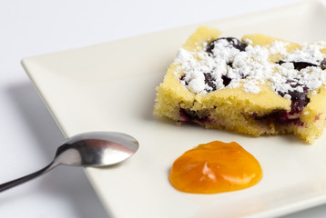 Homemade plum cake on white plate.