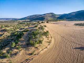 footprints and vehicle tracks on sand