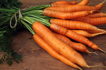 Fresh raw carrots on wooden table