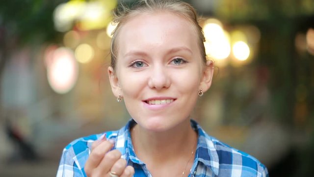 girl on the street finger brushing her teeth. beautiful woman outdoors