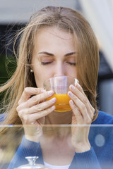 Woman with tea cup. Tea with sea buckthorn and honey on cafe bac