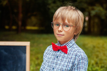 stylish blond little boy with glasses. Back to school concept.