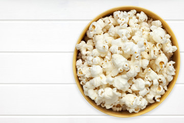 Popcorn in Yellow Bowl over white Timber Top View