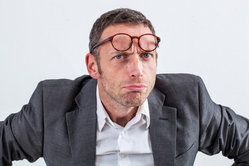 unhappy businessman with eyeglasses on his forehead for suspicion