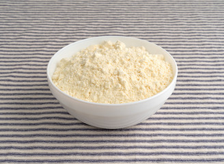 French vanilla cake mix in a white bowl on a striped tablecloth.