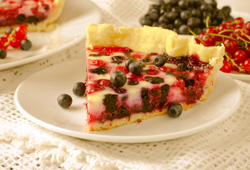 Mix berry tart, pie, cake with raspberries, bilberries, bluberries, red currant and cream on white background