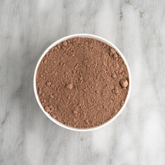 Devil's food cake mix in a white bowl on a gray marble counter top.