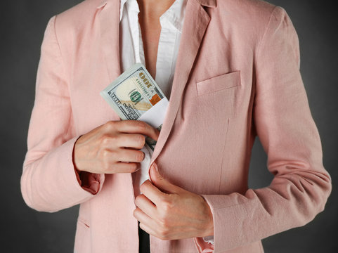 Woman with money on dark background
