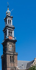Amsterdam, the Netherlands - August 16, 2016: The Westerkerk against blue sky with lots of people and traffic in front.