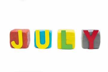 word July by wooden letter on clay