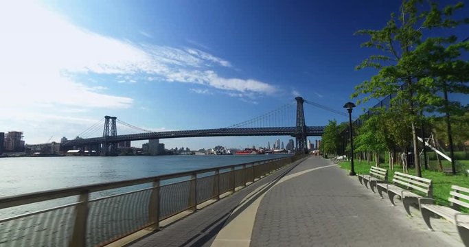 A bike rider's forward perspective on the East River Bikeway with the Williamsburg Bridge in the background.  	