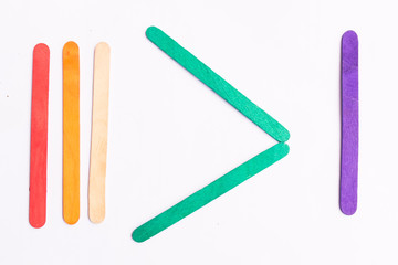 colorful of Ice cream sticks with greater than sign on white background