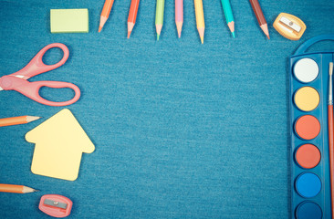 School supplies and shape of building on jeans background, back to school concept, copy space for text