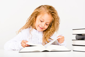 Portrait of a beautiful little girl with a book. The child reads