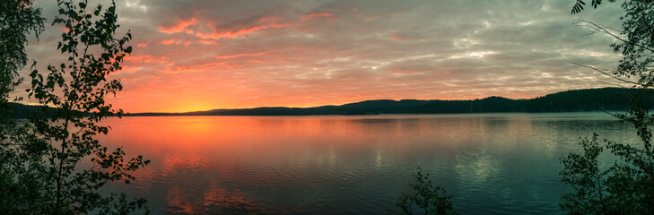 heldere zonsopgang aan de oever van het bosmeer