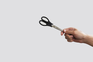 Scissors in hand. Isolated on grey background