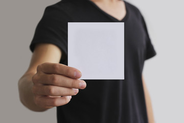 Man showing blank white square flyer brochure booklet. Leaflet p