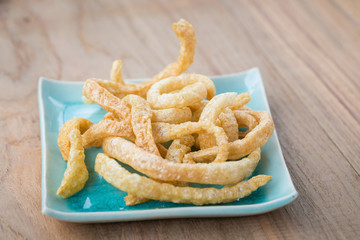 Pork rind junk food snack on a wooden table