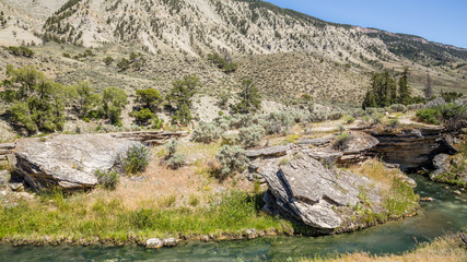 Fototapeta premium Rocky shore of the river. River in the mountains. Amazing landscape of riverside. Boiling River Trail, Yellowstone National Park, Wyoming