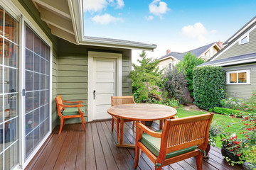 Back deck of guest house with wooden table set