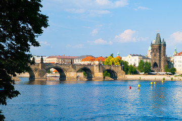 Obraz premium Charles Bridge, aka Karluv most, and Vltava river in Prague city centre on sunny summer day with blue sky, Czech Republic