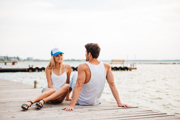 Loving couple sitting at the wooden pier