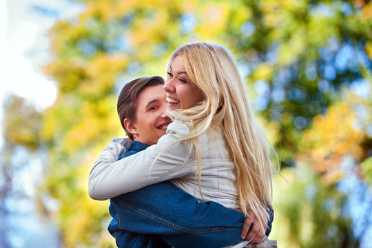 Young couple in love hugging and flirting in autumn park. Good wether in fall park for young couple in love.
