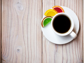 Cup of coffee with jujube candies on the wooden background