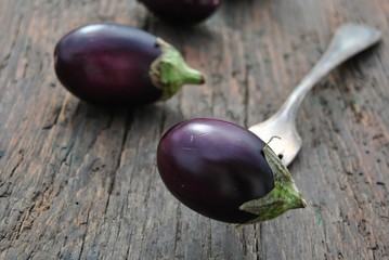 Aubergine auf Holz mit Gabel (Solanum melongena) 