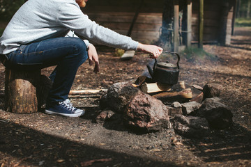 a man sitting by the campfire in the forest