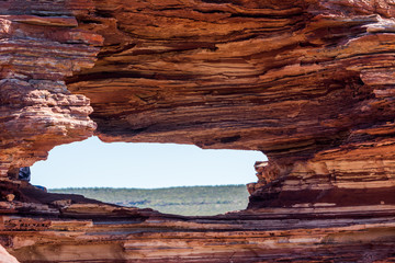 Scenic Panorama from lookout through nature window over gorge in Kalbarri National Park, in outback Western Australia, Murchison River, rough rugged rock formation, summer sunny blue sky, copy space