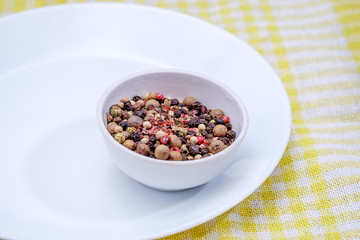 Bowl of various pepper on white plate