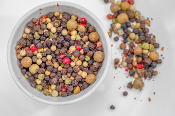 Bowl of various pepper on white plate