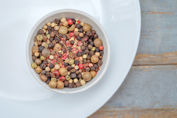 Bowl of various pepper on white plate