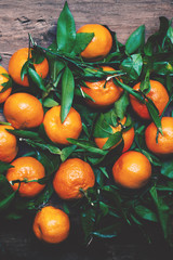 Tangerines with leaves on wooden background. Mandarins Tangerine