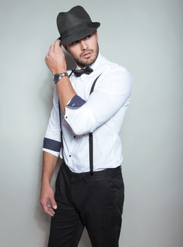 handsome young man wearing hat, suspenders, bow tie and a watch
