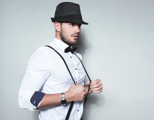 handsome young man wearing hat, suspenders, bow tie and a watch
