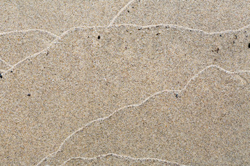 Abstract pattern of waves on a sandy beach