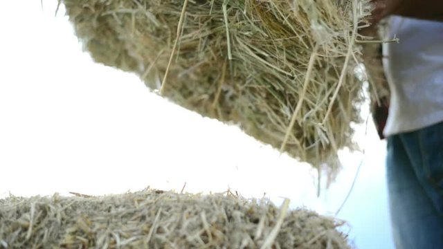 portrait of farmer and harvest. strawbale in hands